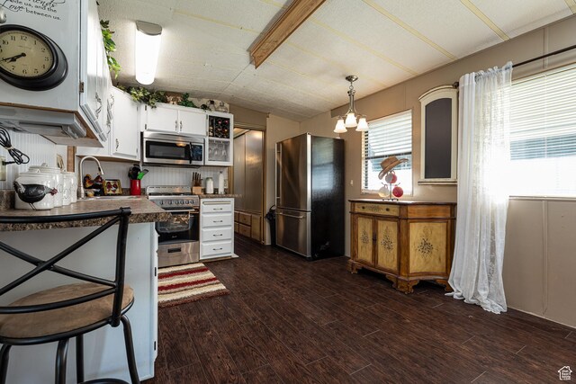 325 S Main St, Glendale, UT 84729 - kitchen with appliances with stainless steel finishes, vaulted ceiling, dark wood-style floors, white cabinetry, and dark countertops