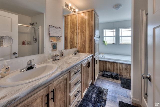 bathroom with a shower stall, a bath, double vanity, and a sink