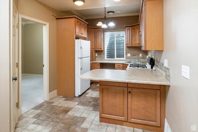 232 Bugle Way, Providence, UT 84332 - kitchen with light countertops, freestanding refrigerator, a peninsula, baseboards, and ornamental molding