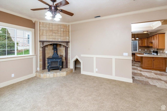 232 Bugle Way, Providence, UT 84332 - unfurnished living room featuring crown molding, a wood stove, a ceiling fan, and light carpet