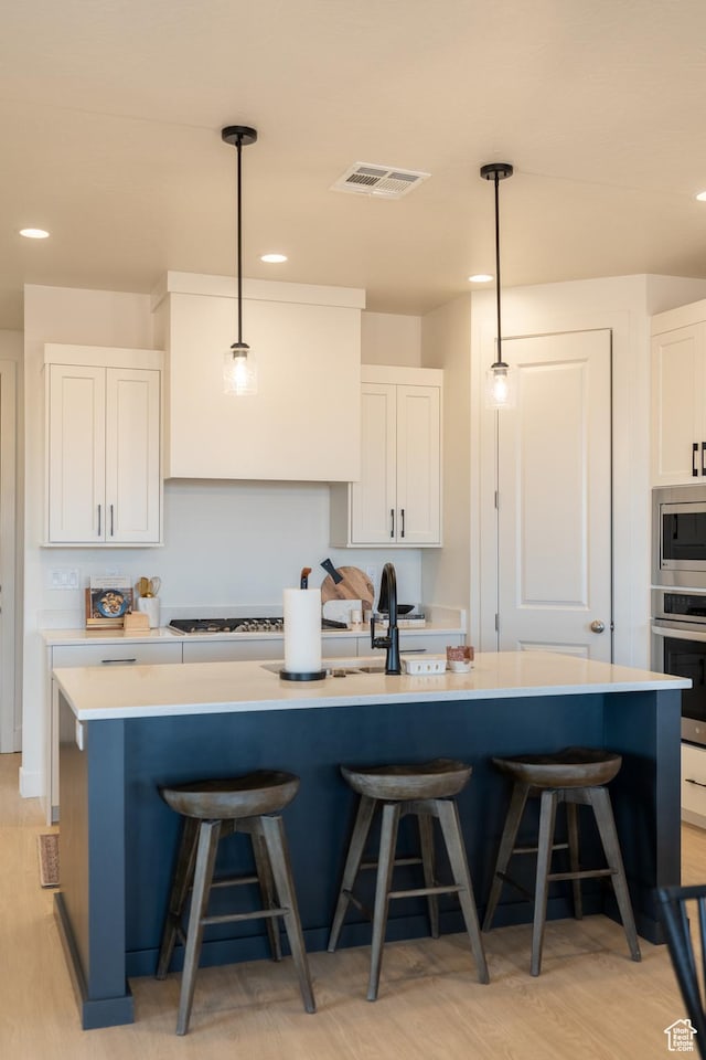 5394 S Aquamarine Ln, St George, UT 84790 - kitchen with a center island with sink, white cabinets, and appliances with stainless steel finishes