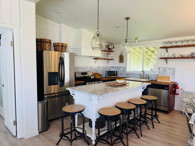 594 S Aspen Dr Unit 48, Garden City, UT 84028 - kitchen with stainless steel appliances, open shelves, a kitchen island, and light wood-style floors