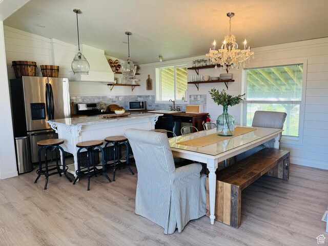 594 S Aspen Dr Unit 48, Garden City, UT 84028 - dining area with light wood-style flooring, a chandelier, and healthy amount of natural light