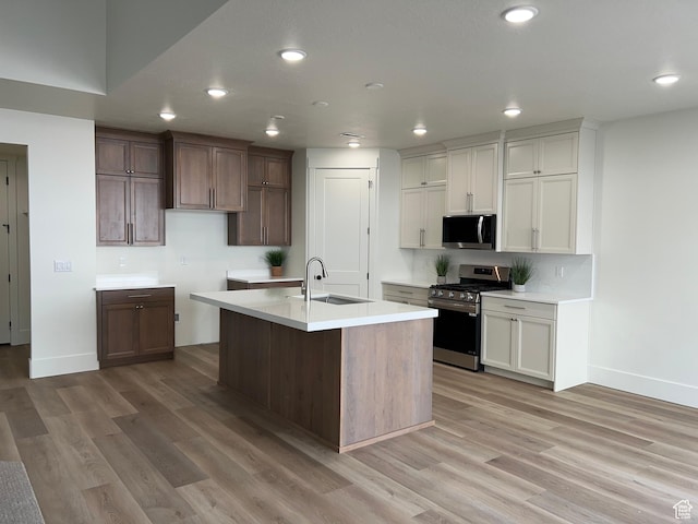 1136 N 1875 E Unit 1, Layton, UT 84040 - kitchen featuring stainless steel appliances, baseboards, a sink, light wood-style flooring, and a kitchen island with sink