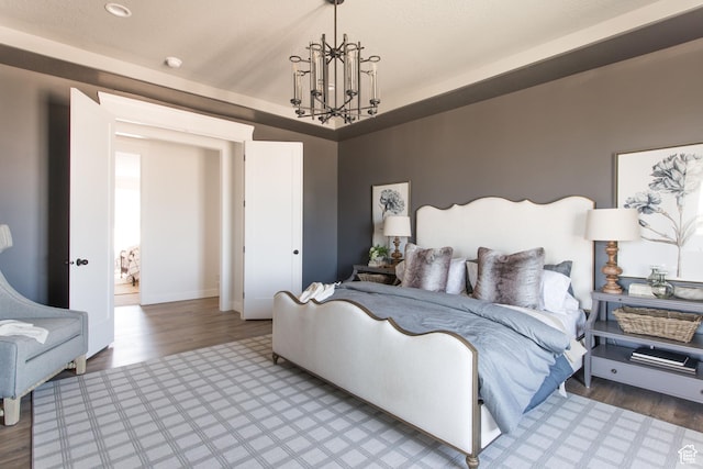 bedroom with wood finished floors and a chandelier