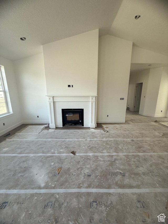 314 N 1040 E Unit 24, Salem, UT 84653 - unfurnished living room with baseboards, vaulted ceiling, a fireplace, and a textured ceiling