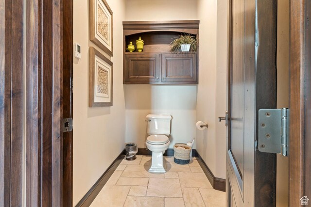 2596 E Flint St, St George, UT 84790 - bathroom with baseboards, toilet, and stone tile floors