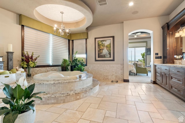 2596 E Flint St, St George, UT 84790 - full bathroom featuring connected bathroom, stone tile flooring, vanity, visible vents, and a garden tub