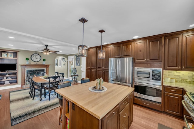 2218 W 2575 N, Cedar City, UT 84721 - kitchen with pendant lighting, stainless steel appliances, a glass covered fireplace, open floor plan, and light stone countertops