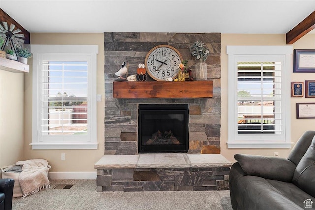living area with a wealth of natural light, carpet, a fireplace, and visible vents
