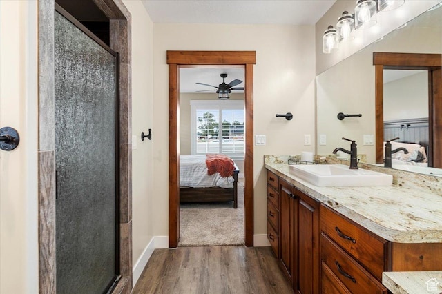 bathroom featuring a shower stall, wood finished floors, ceiling fan, and ensuite bathroom