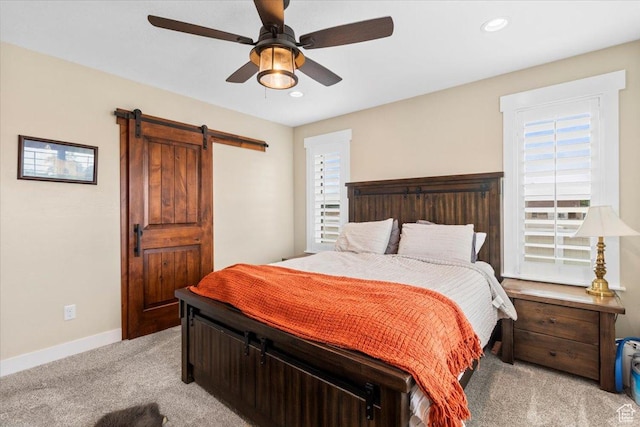 bedroom with light colored carpet, recessed lighting, baseboards, a barn door, and ceiling fan