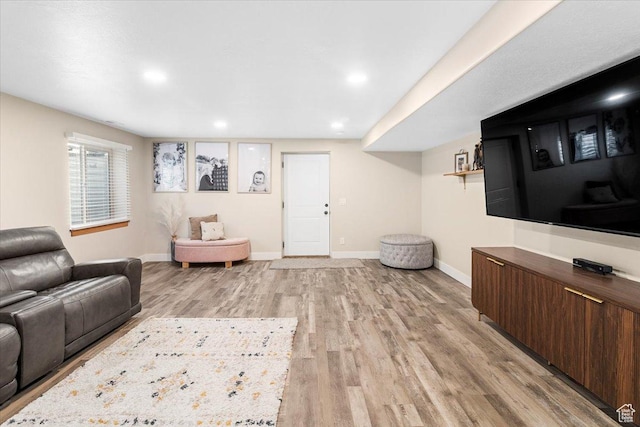 living area with baseboards, light wood-style floors, and recessed lighting