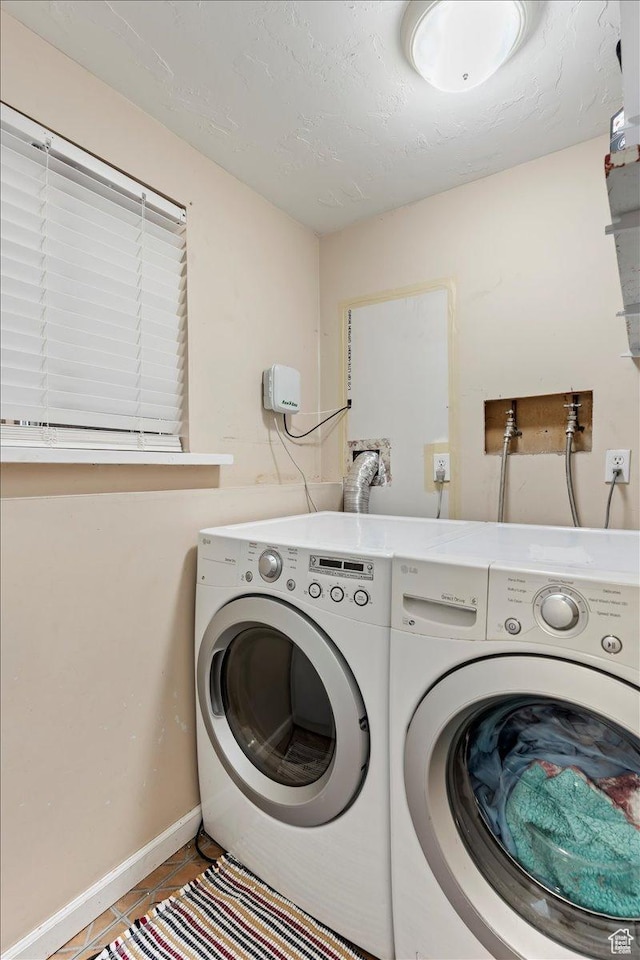 washroom with tile patterned floors, laundry area, a textured ceiling, and separate washer and dryer