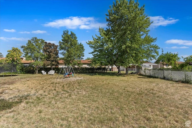 view of yard with a fenced backyard, a playground, and a trampoline