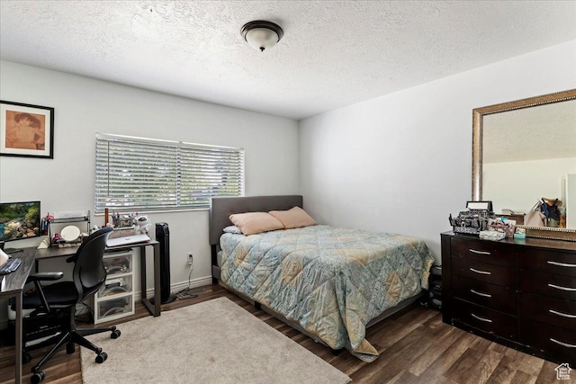 bedroom with dark wood-style flooring and a textured ceiling