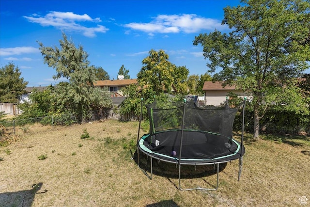 view of yard with a trampoline and fence