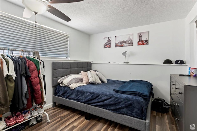 bedroom with a textured ceiling, ceiling fan, and wood finished floors