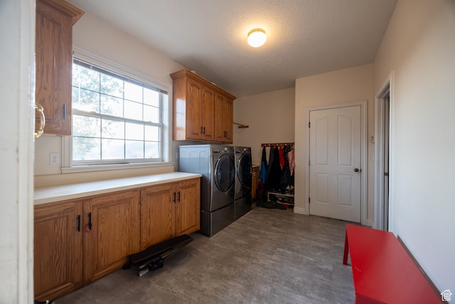 laundry room with a textured ceiling, cabinets, and washer and dryer