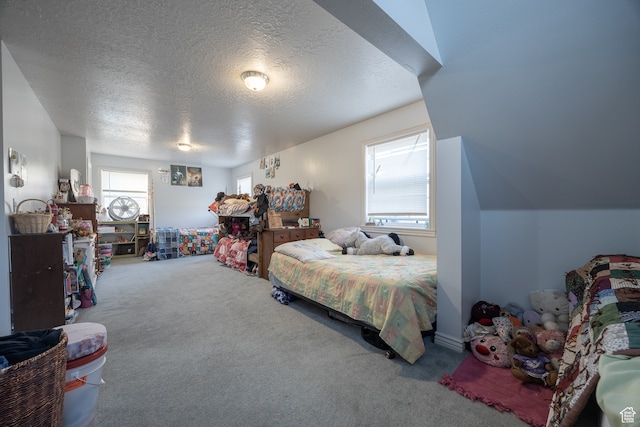 carpeted bedroom with a textured ceiling and lofted ceiling