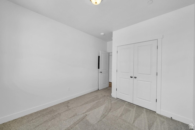 unfurnished bedroom featuring a closet, baseboards, and carpet