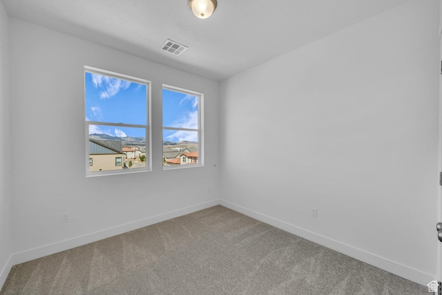 spare room featuring visible vents, baseboards, and carpet