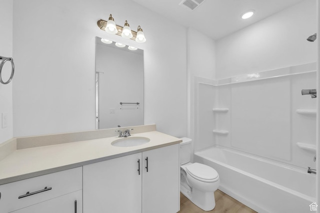 full bath featuring vanity, wood finished floors, visible vents, bathing tub / shower combination, and toilet
