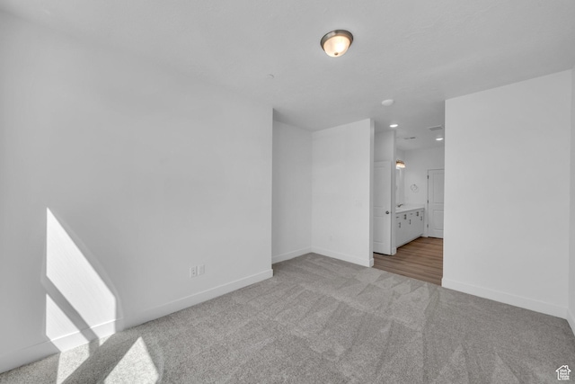carpeted spare room featuring baseboards
