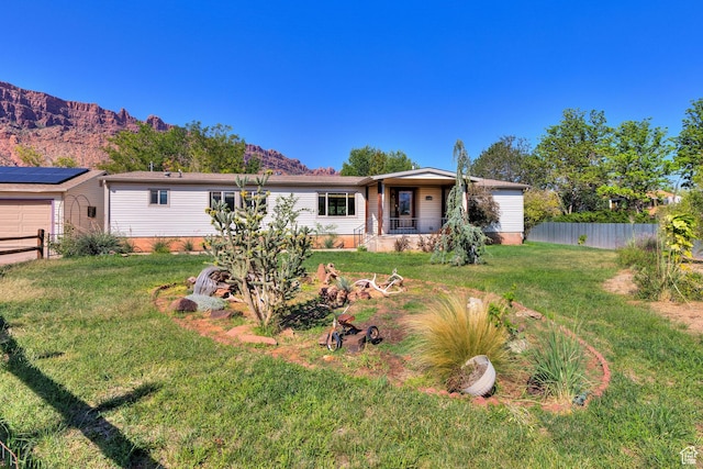 view of front of home with a front yard, fence, and a mountain view