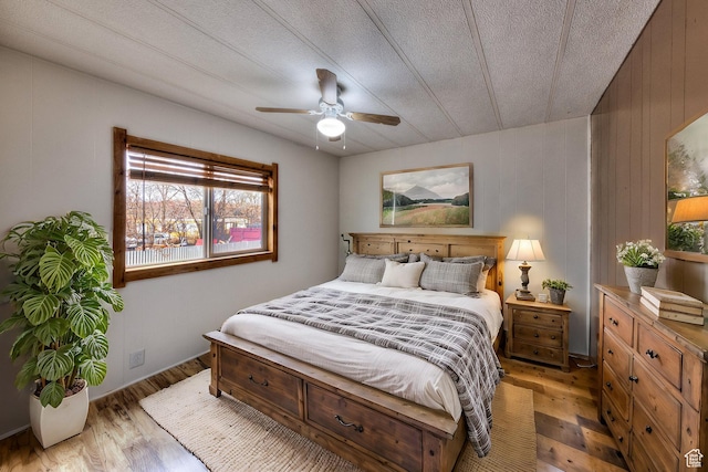 bedroom with ceiling fan, light wood-type flooring, and a textured ceiling