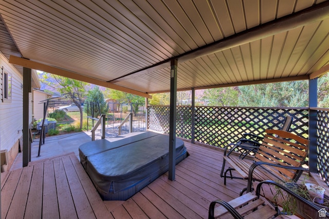 wooden deck with hot tub deck surround