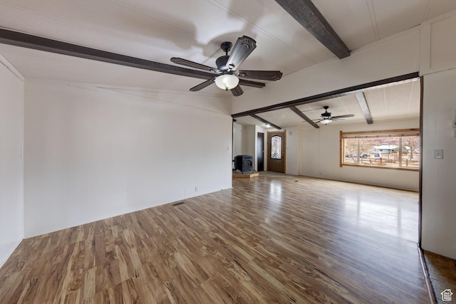unfurnished living room featuring lofted ceiling with beams, a ceiling fan, and wood finished floors