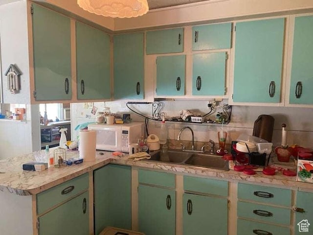 215 W 200 S, Duchesne, UT 84021 - kitchen with light countertops, white microwave, a sink, and a peninsula
