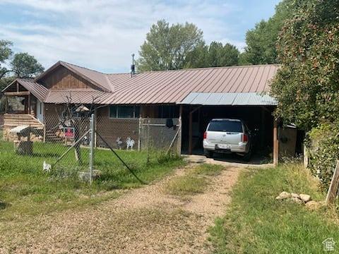 215 W 200 S, Duchesne, UT 84021 - view of front of house with a carport, dirt driveway, fence, and metal roof