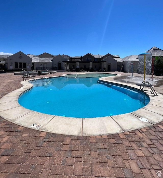 pool featuring a patio and a residential view