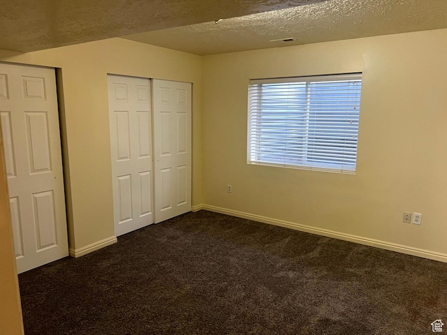 14112 S Senior Band Rd, Draper, UT 84020 - unfurnished bedroom with baseboards, visible vents, a textured ceiling, and dark carpet