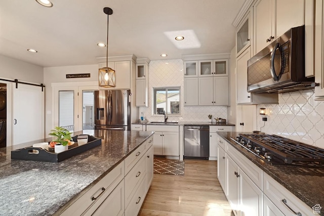 1806 S Summit Haven Dr Unit 1, Francis, UT 84036 - kitchen featuring backsplash, a sink, light wood-style floors, hanging light fixtures, and appliances with stainless steel finishes