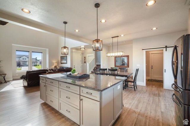 1806 S Summit Haven Dr Unit 1, Francis, UT 84036 - kitchen with a barn door, dark stone countertops, freestanding refrigerator, a center island, and open floor plan