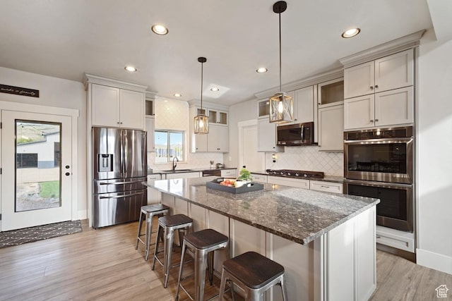 1806 S Summit Haven Dr Unit 1, Francis, UT 84036 - kitchen featuring light wood finished floors, a center island, a sink, tasteful backsplash, and appliances with stainless steel finishes