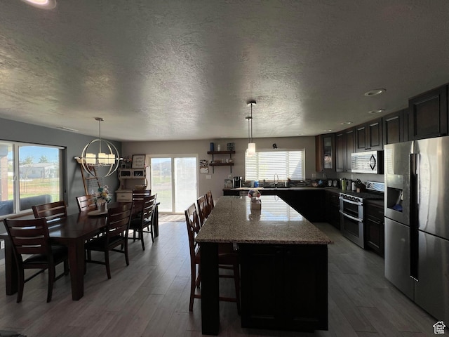 472 W 2300 S Unit 18, Richfield, UT 84701 - kitchen with dark wood-type flooring, a sink, a kitchen island, appliances with stainless steel finishes, and light stone countertops