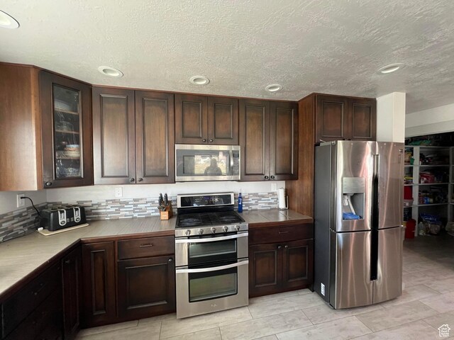 472 W 2300 S Unit 18, Richfield, UT 84701 - kitchen with dark brown cabinets, stainless steel appliances, and glass insert cabinets