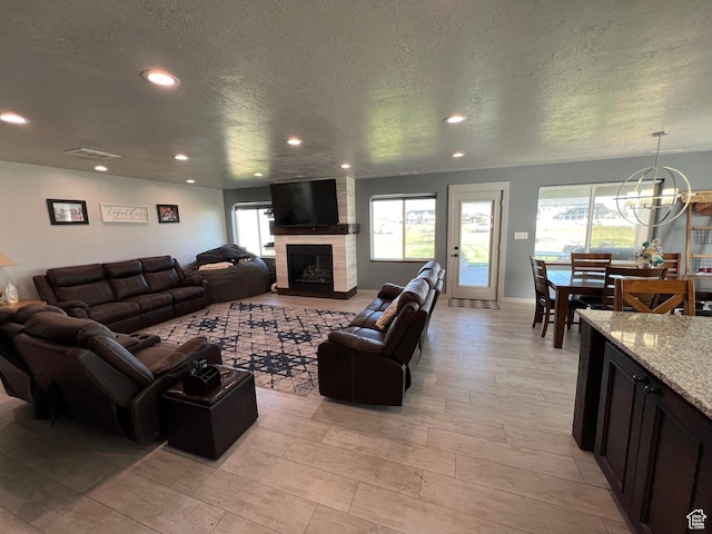 472 W 2300 S Unit 18, Richfield, UT 84701 - living room featuring baseboards, recessed lighting, a fireplace, a textured ceiling, and a chandelier