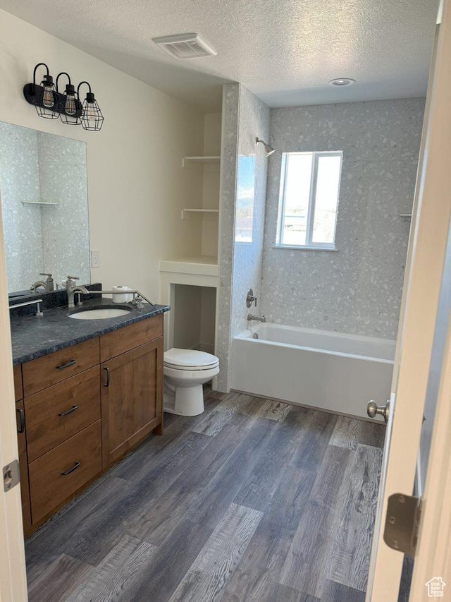 full bathroom featuring visible vents, toilet, a textured ceiling,  shower combination, and wood finished floors