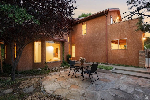 2328 W 300 N, Provo, UT 84601 - back of property at dusk featuring stucco siding, outdoor dining area, and a patio area