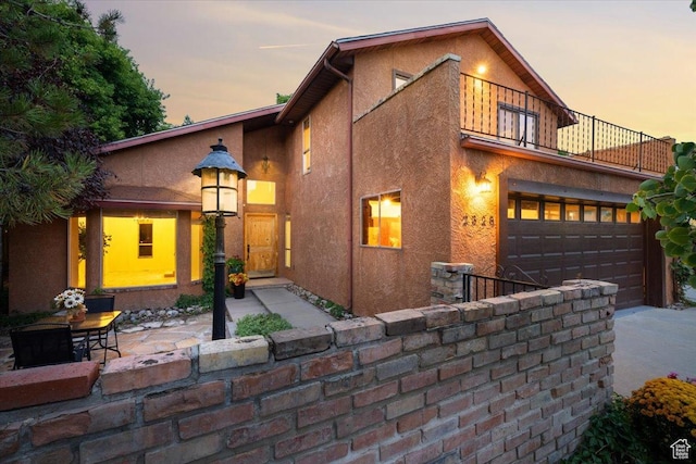 2328 W 300 N, Provo, UT 84601 - view of front of property with stucco siding, driveway, a patio, an attached garage, and a balcony