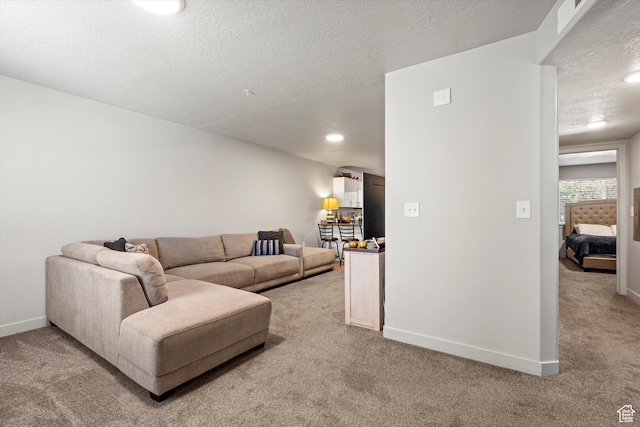 living area with a textured ceiling, visible vents, recessed lighting, light carpet, and baseboards