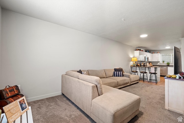 living room with baseboards, recessed lighting, and light colored carpet
