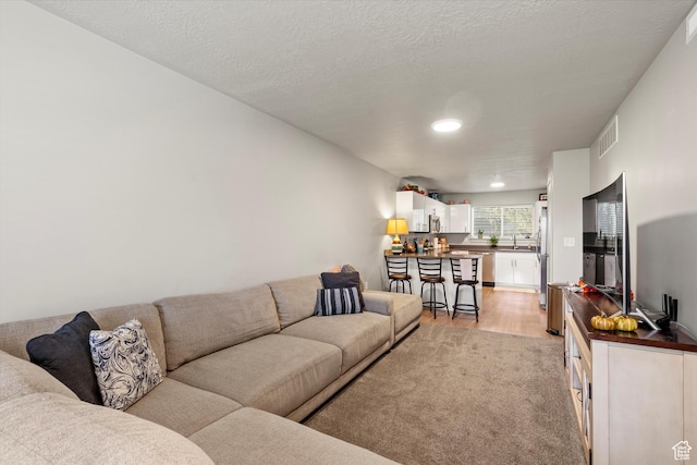 living room featuring recessed lighting, light wood-style floors, and visible vents