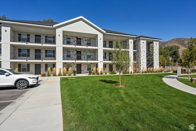 view of building exterior with uncovered parking and a mountain view