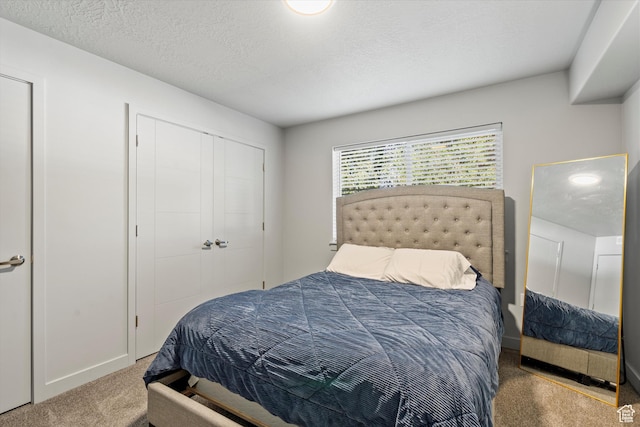 bedroom with carpet flooring, a closet, and a textured ceiling